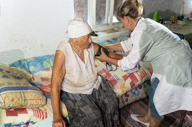 A member of one of Project HOPE's Mobile Medical Units in Ukraine providing care to a resident of Prymorske village in Zaporzhizhia oblast, which is 12 kilometers from the conflict. Photo by Nikita Hlazyrin for Project HOPE, 2023. 