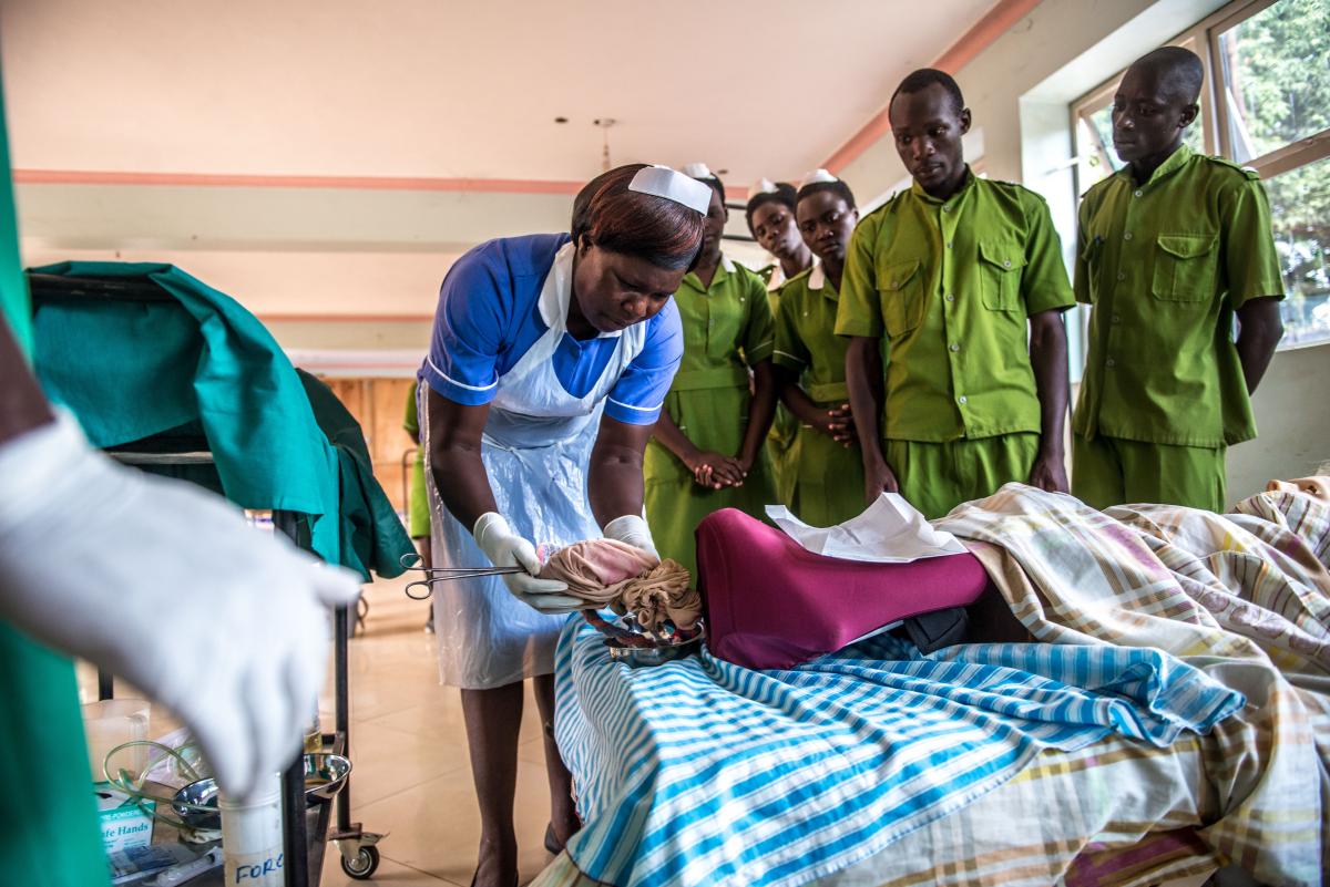 A midwife conducts a practical exercise with students.