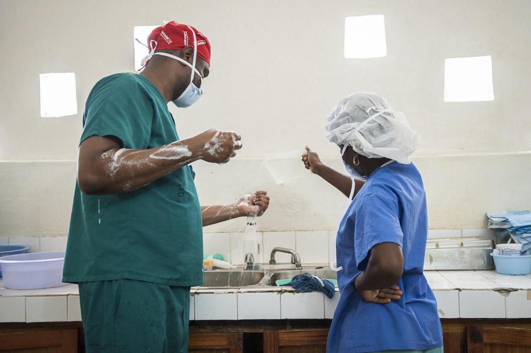 A nurse pours water from a pitcher to help the surgeon scrub for a cesarean section at St. Therese Hospital in Central Plateau, Haiti. © 2014 C. Hanna-Truscott/Midwives for Haiti, Courtesy of Photoshare