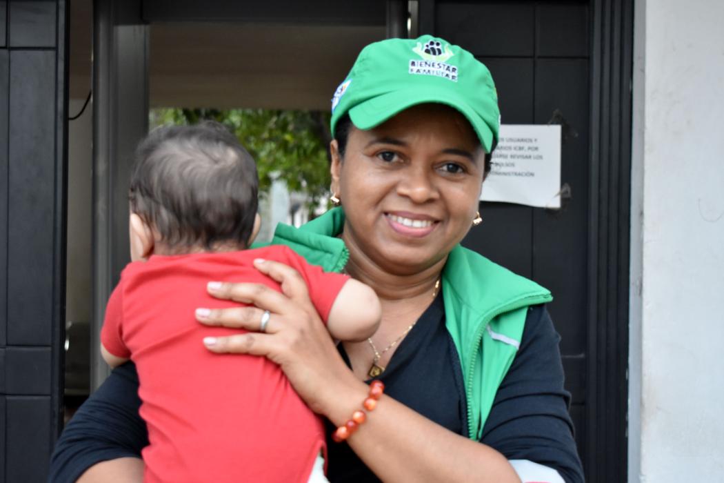 Nilbellys Pimienta Ramirez, a social worker with the Colombian Family Welfare Institute, holds a baby during a house visit in Riohacha. Photo credit: HRH2030 Colombia.