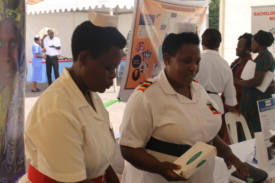 Venny and fellow midwife from Kabale demonstrate how to safely insert and remove contraceptive implants during the &quot;Mini University&quot; segment at the Nurses and Midwives Symposium. Photo by Gillian Leitch for Jhpiego Uganda.