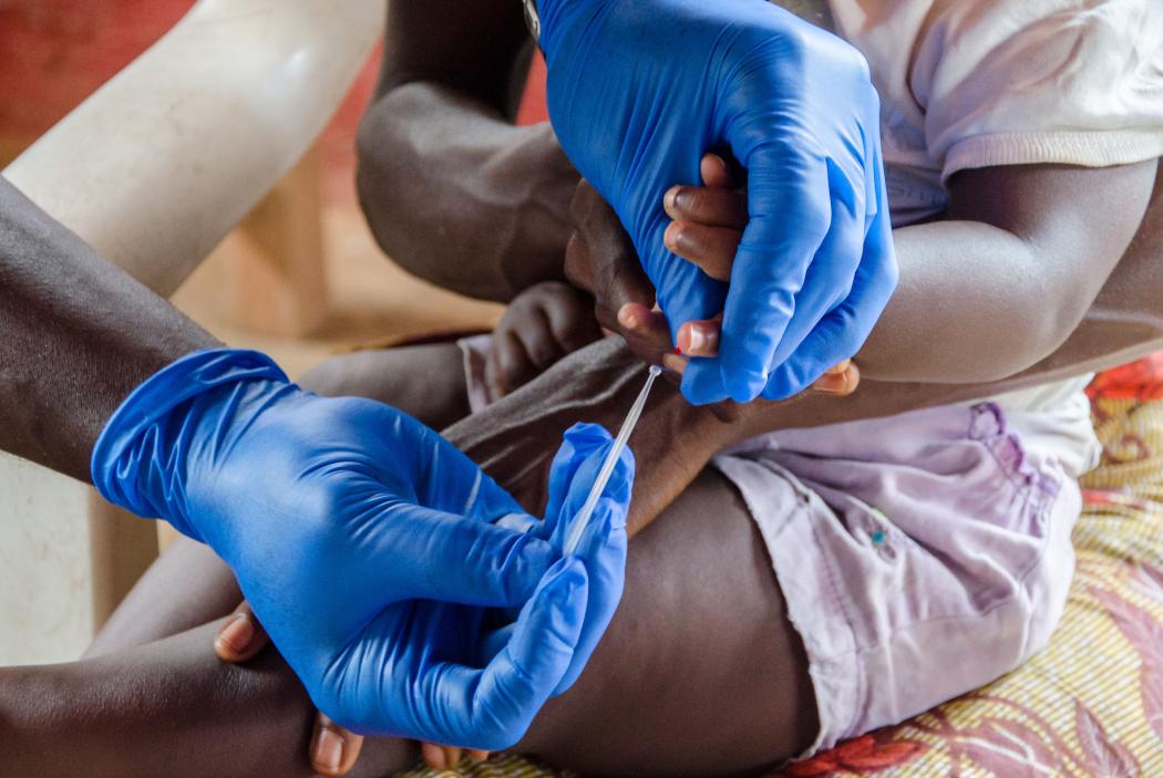 A community health worker conducts a rapid diagnostic test for malaria on a child in Liberia. Photo credit: Last Mile Health.