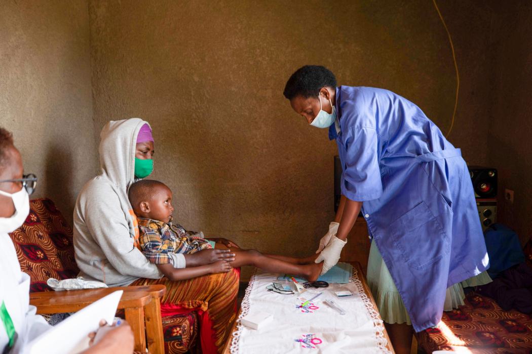 Ruth Uwibohoye, a health worker, cares for a child at Nyanza Hospital in Nyanza District, Rwanda. Ruth is supported by the IntraHealth International-led and USAID-funded Ingobyi project to reduce preventable infant and maternal deaths, reduce the incidence of malaria, and bring high-quality, integrated health services to more Rwandan mothers, children, and adolescents. Photo by Innocent Ishimwe for IntraHealth.