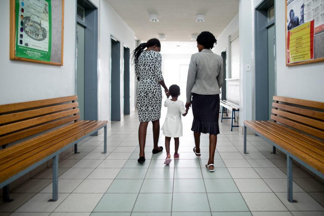 Loide Iikuyu, right, with her daughters Loide (left) and Selma. When the younger Loide was 10 years old, her mother explained to her how and why she came to be HIV-positive. “I told her it was because of mother-to-child transmission,” the elder Loide says, “and that it was not her fault.” Photo by Morgana Wingard for IntraHealth International.