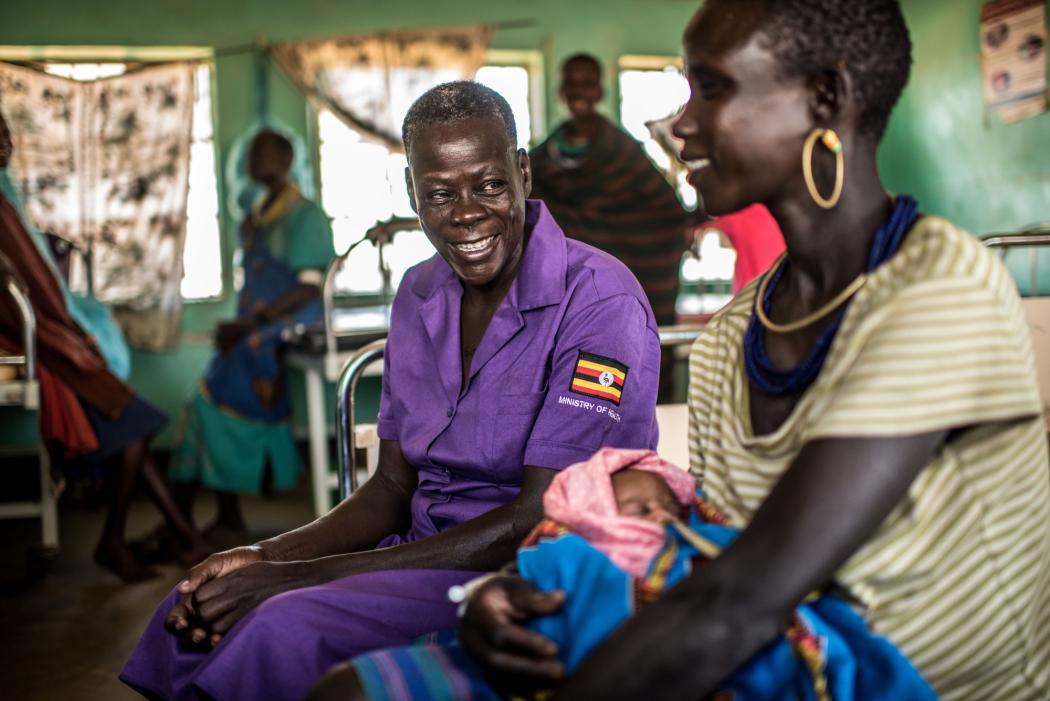 Najore Ruth, a nursing assistant, attends to Angolere Lucy, who delivered her baby in the maternity ward of the Nadunget Health Center 3 in Karamoja, Uganda. Photo by Tommy Trenchard for IntraHealth International.