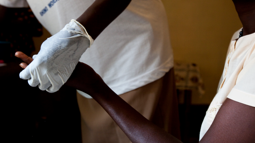 A nurse draws blood to test for HIV and begins counseling a client at the Saint Bakhita Health Centre in Yei, South Sudan. Photo taken by Trevor Snapp for IntraHealth International.