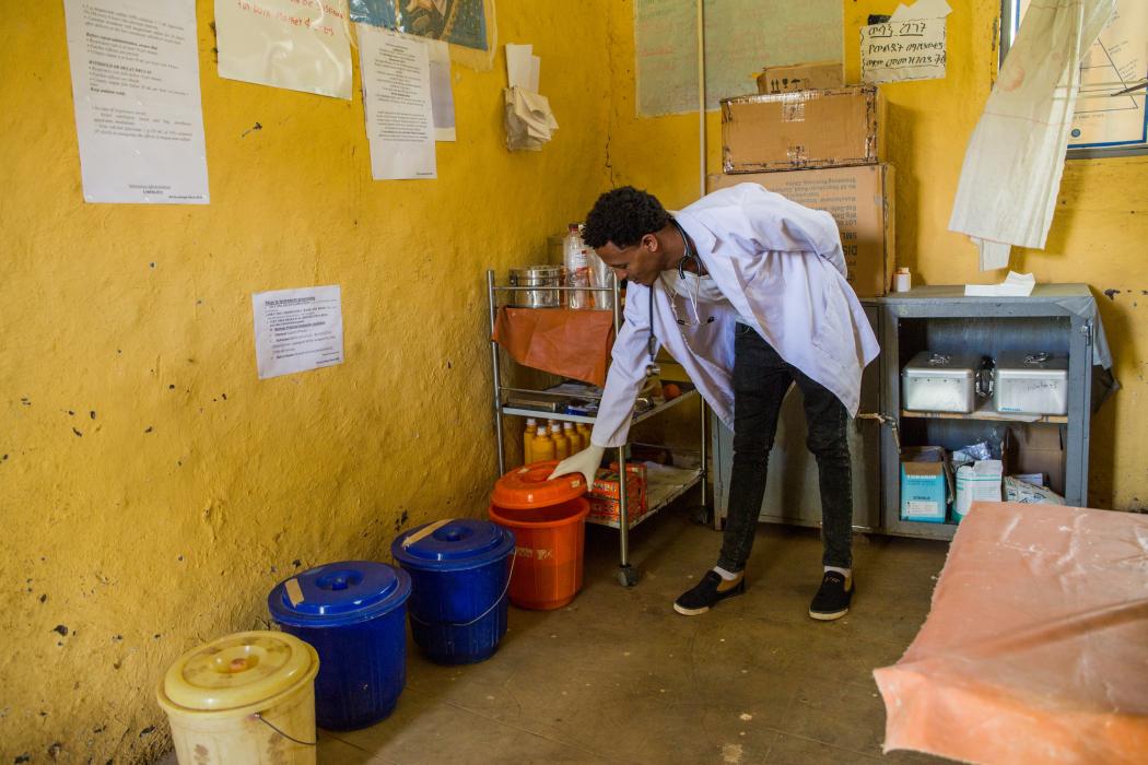 Yaye Wale, 25, a clinical nurse, standing beside buckets of water used for washing medical equipment in the Delivery Room at Yiraber Health Centre, West Gojjam, Ethiopia. Photo credit: WaterAid/ Genaye Eshetu