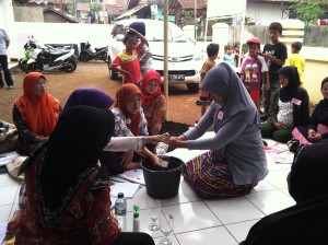 A woman, pregnant with her second child, demonstrates proper handwashing.